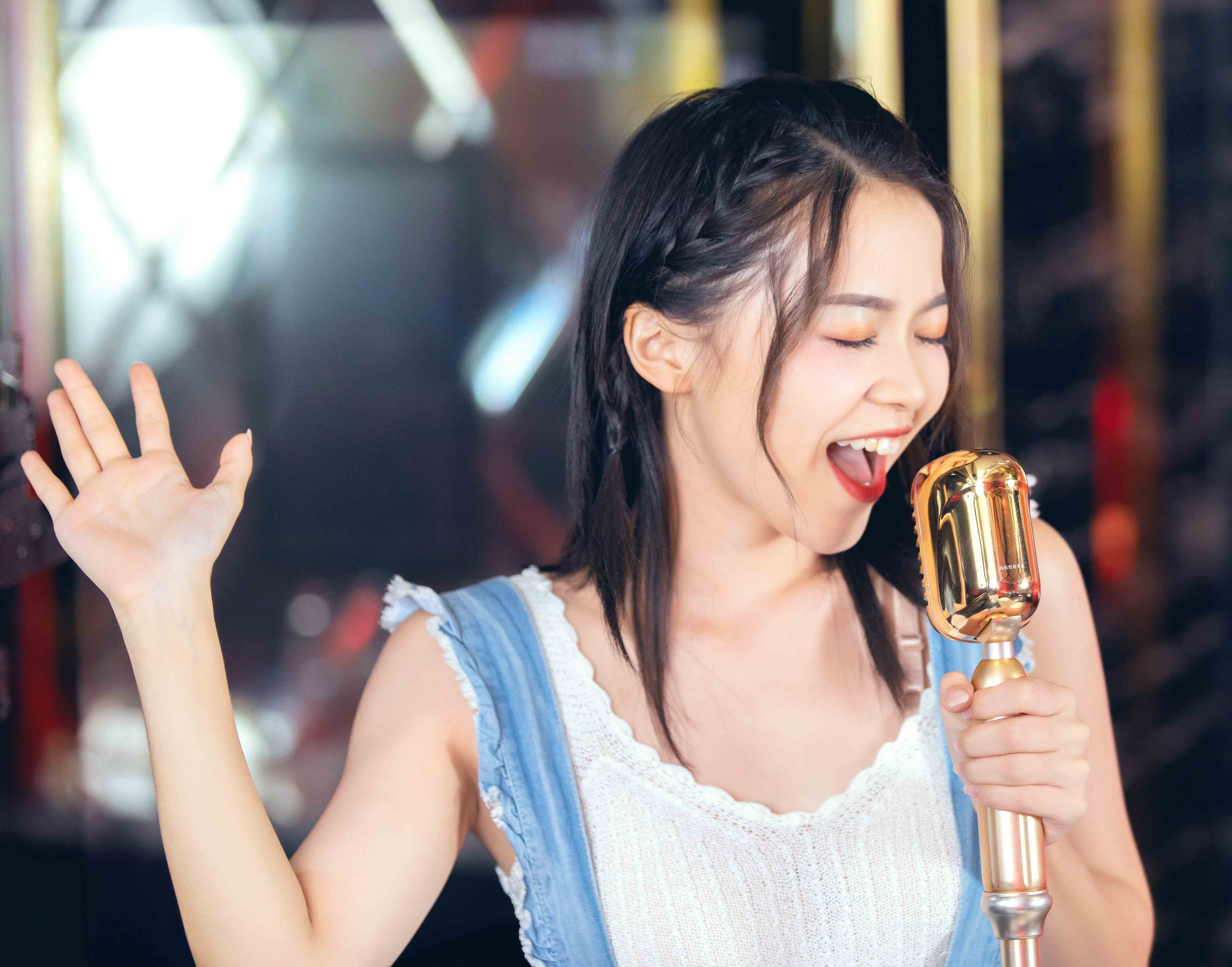 摄图网_501418608_年轻美女在KTV唱歌（企业商用）