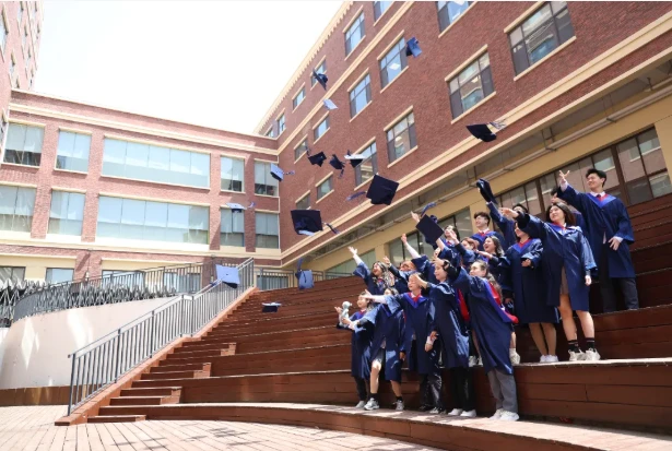毕业图：宏文学子身着学位服，手持UNSW录取通知书与校旗合影
